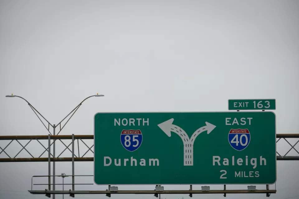 A freeway sign for an intersection showing Interstate 85 for Durham on the left and Interstate 40 for Raleigh on the right.